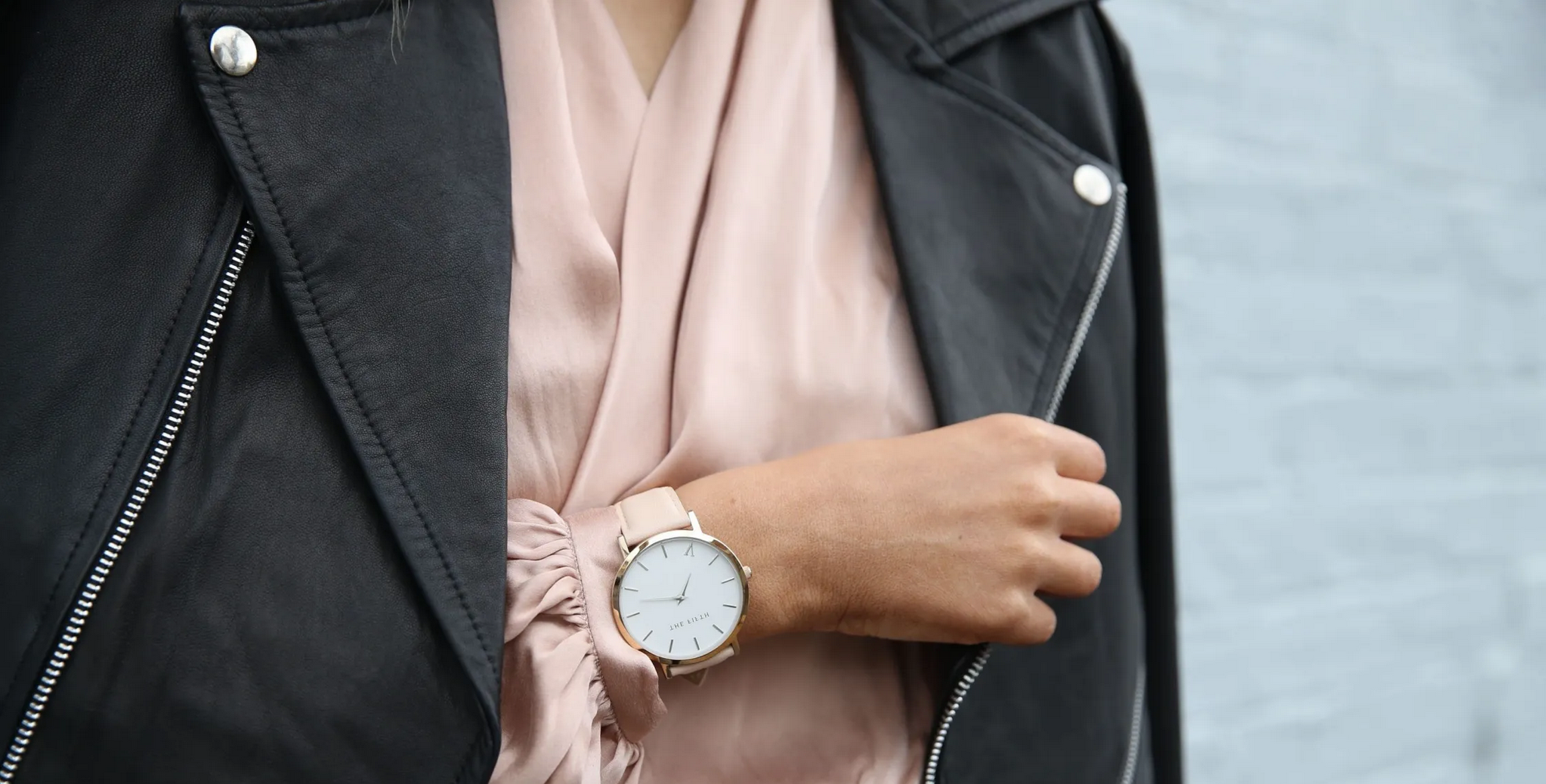 woman wearing silk blouse and leather jacket with watch